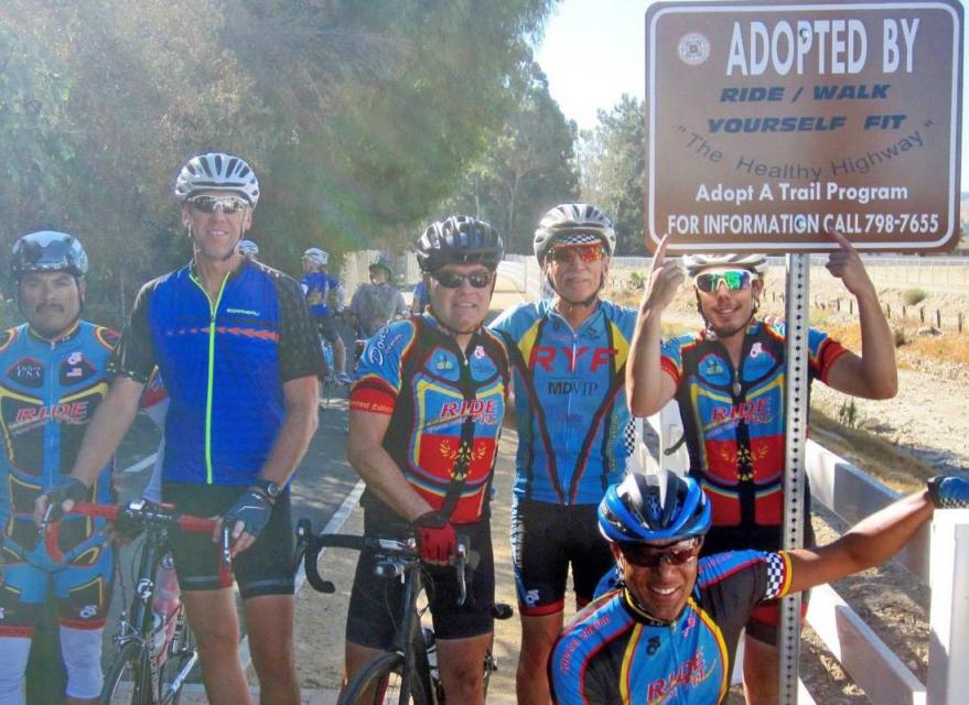 Bike Riders with Adopt a Trail Sign